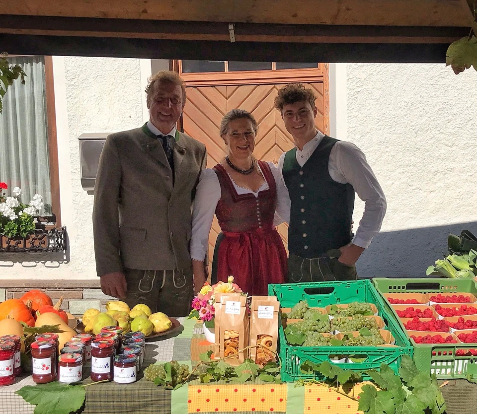 Drei Menschen am Stand mit Trauben, Himbeeren und Eingemachtem