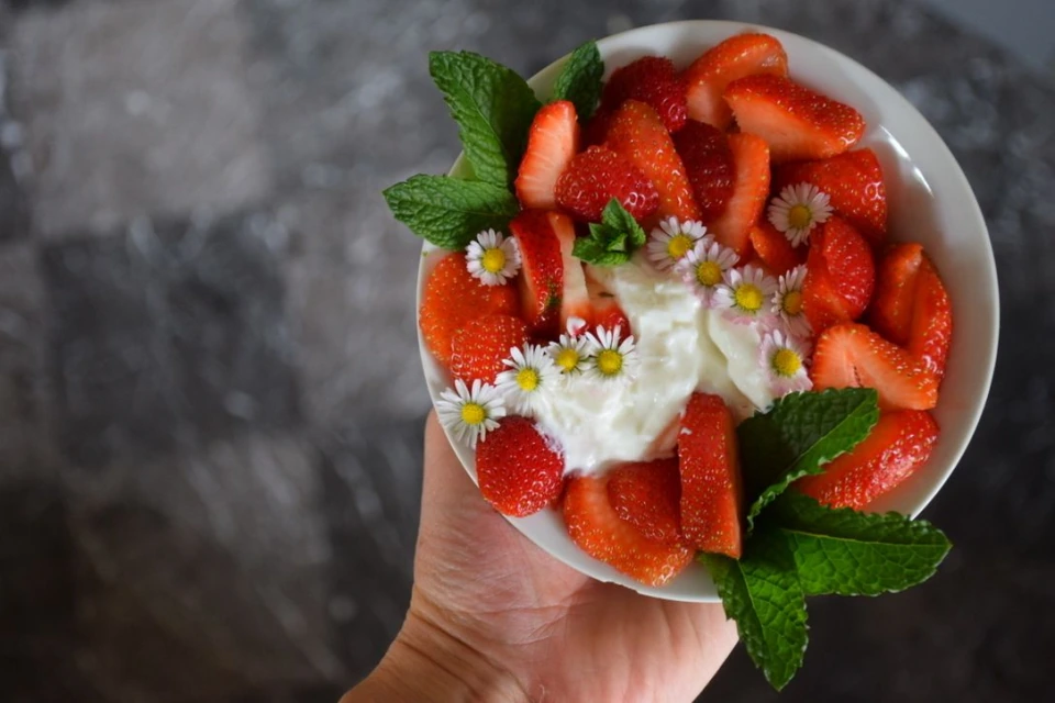 Erdbeerdessert mit Blüten und grünen Blättern